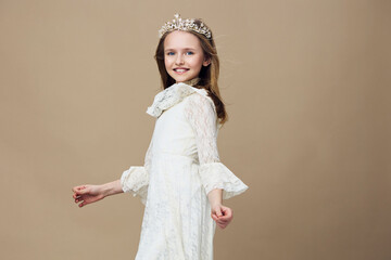 Elegant little girl wearing a lace dress and crown, showcasing joy and innocence, perfect for children s fashion and portrait photography