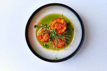 A Delicious Dish of Sautéed Shrimp Served with a Vibrant Green Sauce and Garnished with Fresh Microgreens, Representing Culinary Artistry and Flavorful Innovation