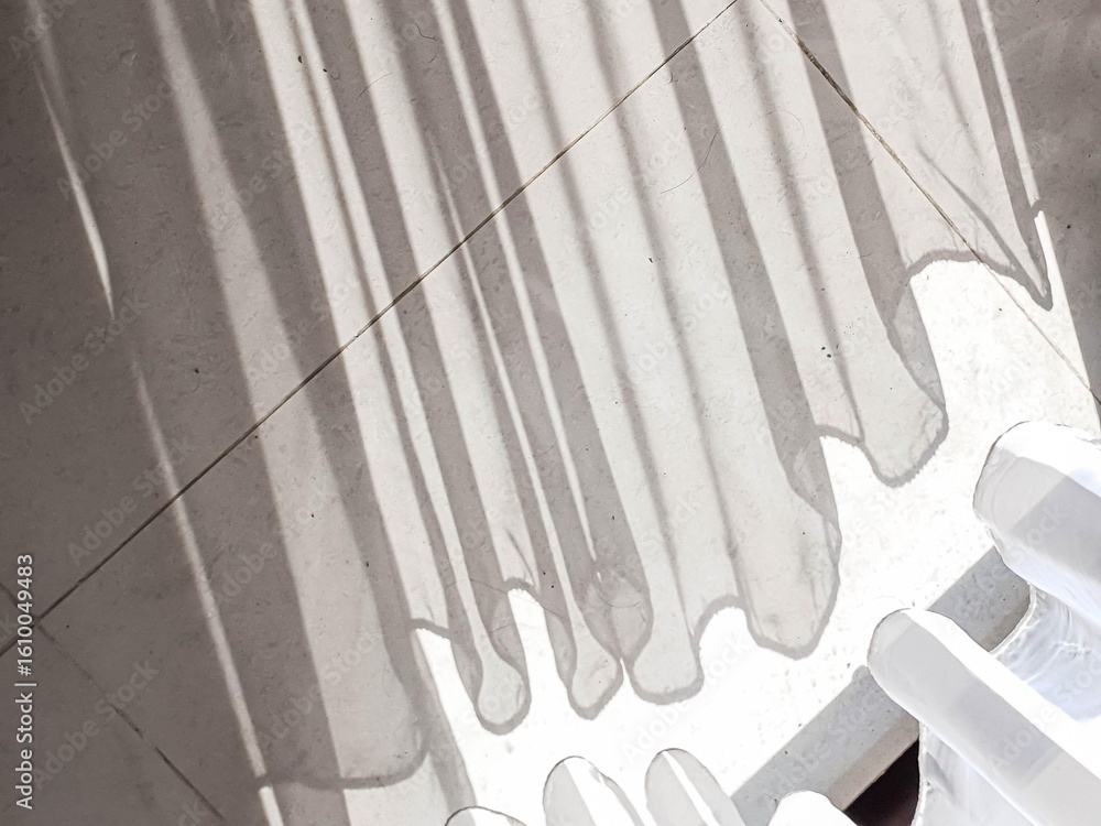 Poster abstract play of sunlight and shadow from curtains on a textured light floor, creating striped patte