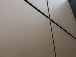 Textured light-colored wall with strong dark lines forming a pattern. Ideal for abstract...