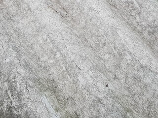 Close-up of a rough, weathered grey concrete or stone surface with subtle textures and cracks,...