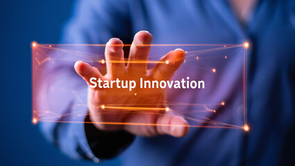 A person reaching towards startup innovation text with a digital interface overlay on a blue background