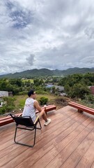 Handsome Man Relaxing on Holiday at a Coffee Shop terrace with Stunning Mountain Views