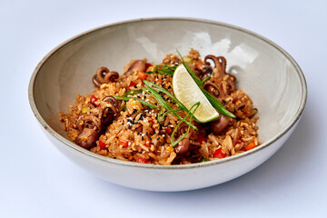 Delicious Plate of Flavorful Rice with Tender Octopus, Fresh Lime, and Vibrant Garnishes for a Savory Dining Experience