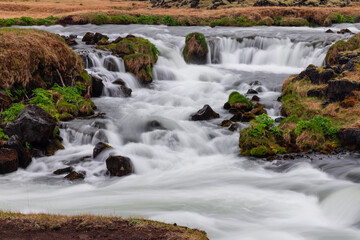Scenic Glacial water falls in iceland countryside during spring time.