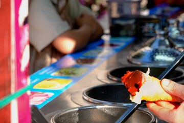 A Maraş ice cream vendor in traditional garb holds a cone. Ice-cold ice cream in the summer heat. Turkey.
