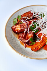 A Delicious Plate Featuring Savory Grilled Fish Accompanied by Colorful Vegetables and Fresh Herbs, Finished with a Garnish of Crispy Rice Noodles