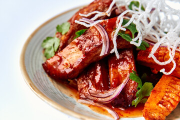 Succulent Glazed Meat Dish Featuring Tender Cuts Topped with Fresh Vegetables and Crispy Garnish for a Delicious Culinary Experience