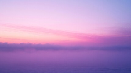 Soft pastel hues of a tranquil sunrise over a misty landscape.