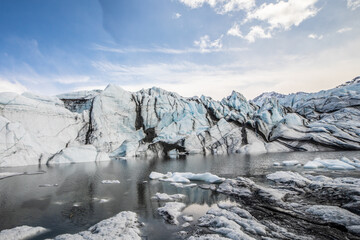 Glacier Front and Meltwater Lake Under Blue Sky