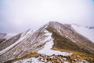 Snowy Mountain Ridge Under Overcast Sky