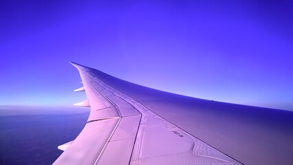 Airplane wing against a purple sky