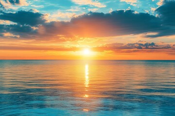 Obraz premium Tranquil ocean horizon glowing with vibrant golden sunset and colorful cloudscape reflection