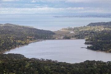 Aerial view of  Nihotupu dam in Titirangi, Auckland, New Zealand surrounded by lush green hills and...