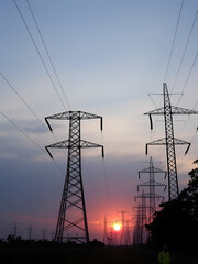 high-voltage power lines, high voltage electric transmission tower for producing electricity at high voltage electricity poles at the sunset.