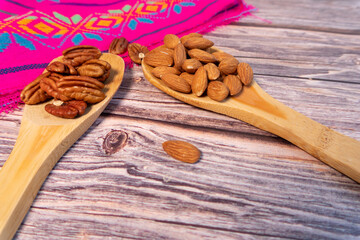 Close-up of a table with walnuts and almonds on a spoon