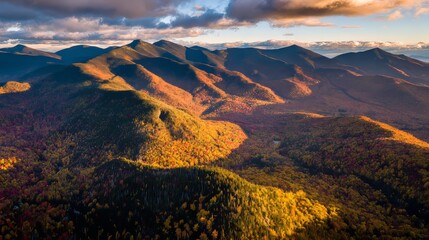 Fototapeta premium Stunning aerial view of colorful fall foliage in New Hampshire with mountains and forests bathed in golden sunlight, showcasing vibrant reds, oranges, yellows, greens, and purples during autumn season