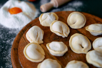 Delightful Dumplings Being Prepared with Flour and Egg on a Wooden Board in a Rustic Kitchen Setting