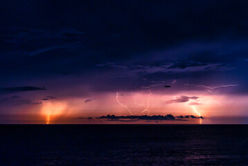 水平線に激しく落雷する海と稲光の夜景