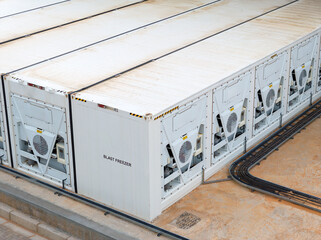 aerial view of refrigerated shipping containers, blast freezer, cold store in front of a warehouse,...