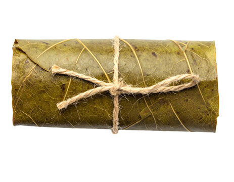 Rolled green leaf bundle tied with rustic natural twine string for herbal packaging on isolated background