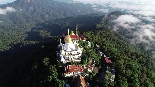 Top down drone view of a temple on top of the mountain suraunded by forest