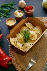 Delicious Dumplings Served in a Box Accompanied by Fresh Ingredients and Dipping Sauces for a Flavorful Culinary Experience