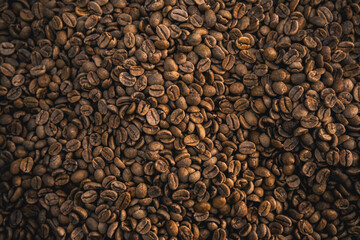 Freshly roasted coffee beans displayed in a textured background, showcasing their rich brown hues and distinct texture, ideal for concepts of coffee culture, mornings, and natural organic products.