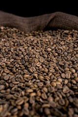 An overflowing burlap sack filled with freshly harvested coffee beans, showcasing richness and...