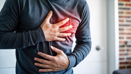 Man clutching chest in pain experiencing heart discomfort with glowing red area indicating distress