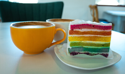 Fresh baked homemade Rainbow cake with coffee on table.