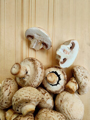 Fresh Whole and Sliced Cremini Mushrooms on Wooden Surface