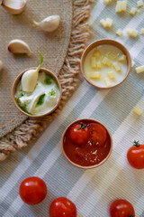 A Colorful Display of Fresh Ingredients and Sauces Perfect for Cooking, Featuring Tomato, Cream, Garlic, and Fresh Herbs in a Natural Setting