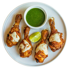 A top-down view of four crispy fried chicken drumsticks on a full visible white ceramic plate