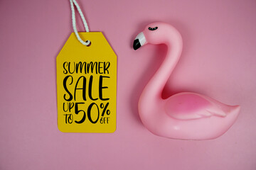 Price tag Sale 50% with pink flamingo summer decorations on pink background
