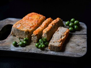 Traditional Indonesian food called Oncon or fermented soybean cake on a cutting board with a black background.