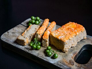 Traditional Indonesian food called Oncon or fermented soybean cake on a cutting board with a black background.