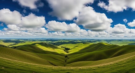 Obraz premium Rolling green hills under a cloudy blue sky