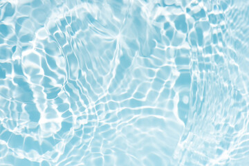 Blue water with ripples on the surface. Defocus blurred transparent blue colored clear calm water surface texture with splashes and bubbles. Water waves with shining pattern texture background.