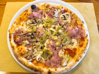 Delicious artichoke and ham pizza with mozzarella and mushrooms