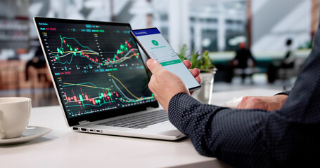 Man Trading Stocks On Laptop At Cafe