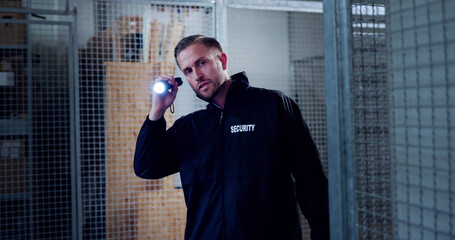 Night Security Officer Shining Flashlight Guarding Warehouse