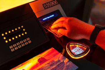 Hand Inserting Cash into Casino Slot Machine.