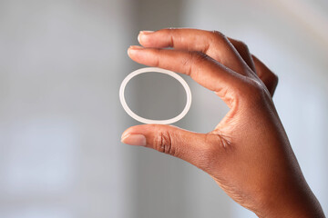 Naklejka na ściany i meble Young African-American Woman Holds Black Contraceptive Ring