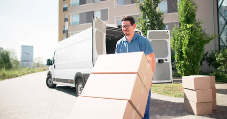 Latinx Mover Unloading Boxes From Van Using Handtruck
