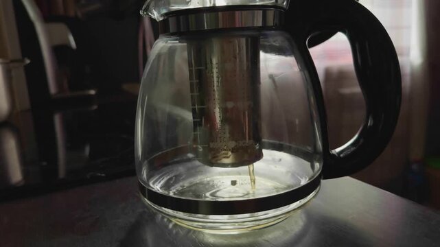  Fresh Tea nfusing in Transparent Kettle .
 Healthy Organic Drink Preparation. Morning Ritual