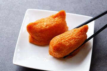 いなり寿司 - 甘辛く煮た油揚げに酢飯を詰めた稲荷寿司
