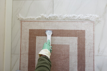 Cleaning a carpet with a handheld device in a bright room