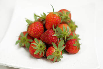 A pile of fresh strawberries isolated on a white background.

