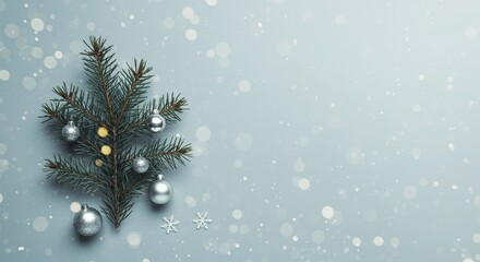 Elegant Christmas tree branch with silver ornaments and snowflakes on a soft blue background